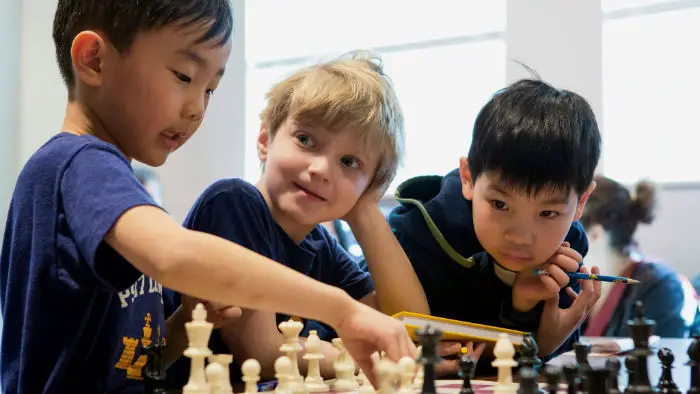 3 Kids Playing Chess In School