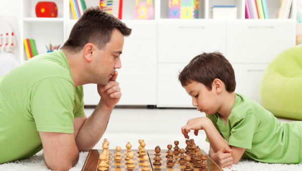 Un papá y su hijo jugando al ajedrez