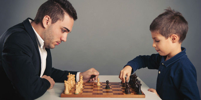A Child & An Adult Playing Chess