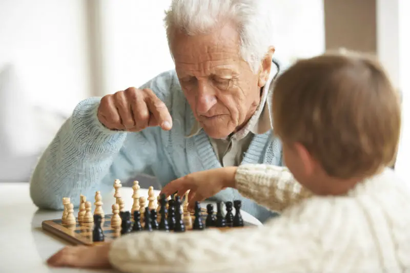 Elderly Man Teaches Grandson About Chess