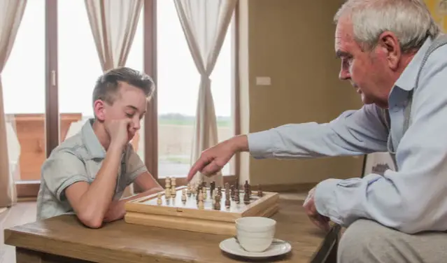A Kid And A Senior Playing Chess